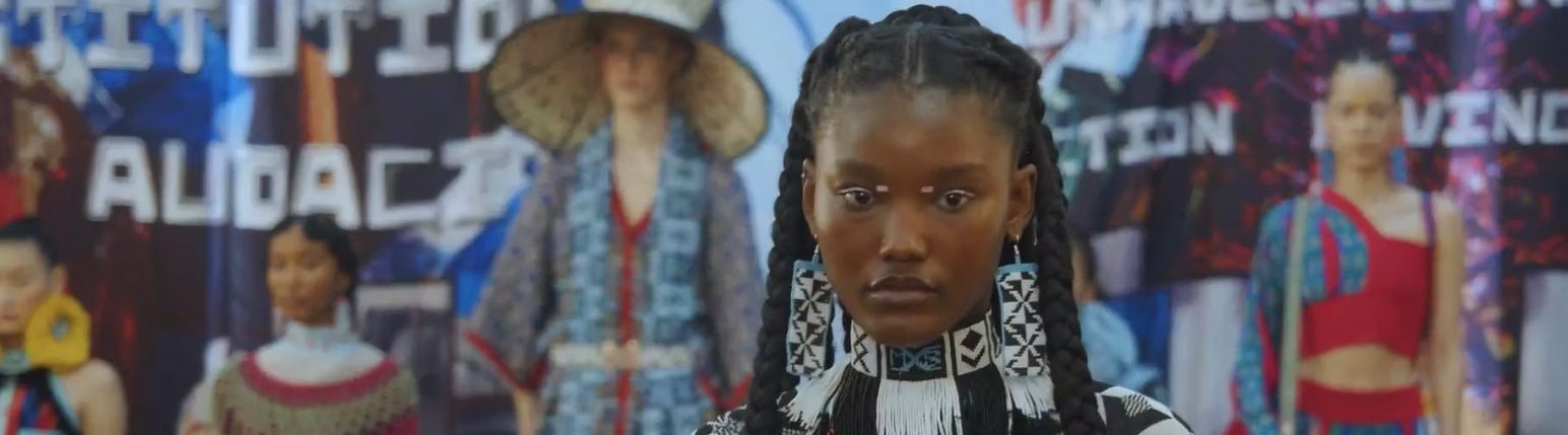Mannequin défilant lors d'un événement de mode avec des motifs traditionnels.